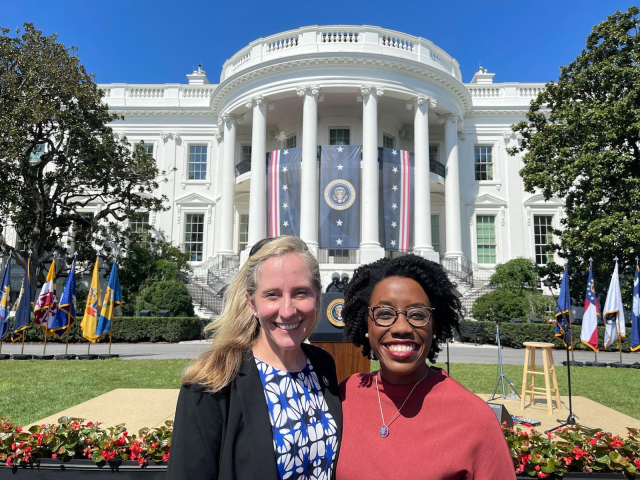 Representatives Underwood and Spanberger smile in front of the White House.