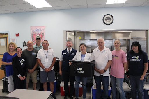 09.02.25_Image_of_Maggie_Standing_with_Staff_at_Meals_On_Wheels_of_Hillsborough_County.jpg Image